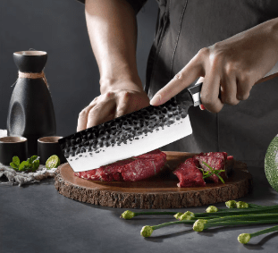 Couteau de cuisine Nakiri en train couper un steak